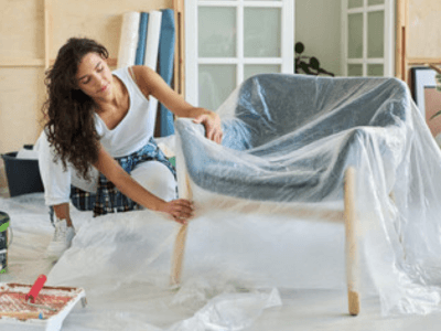 una donna mette un telo in plastica sopra ad una poltrona